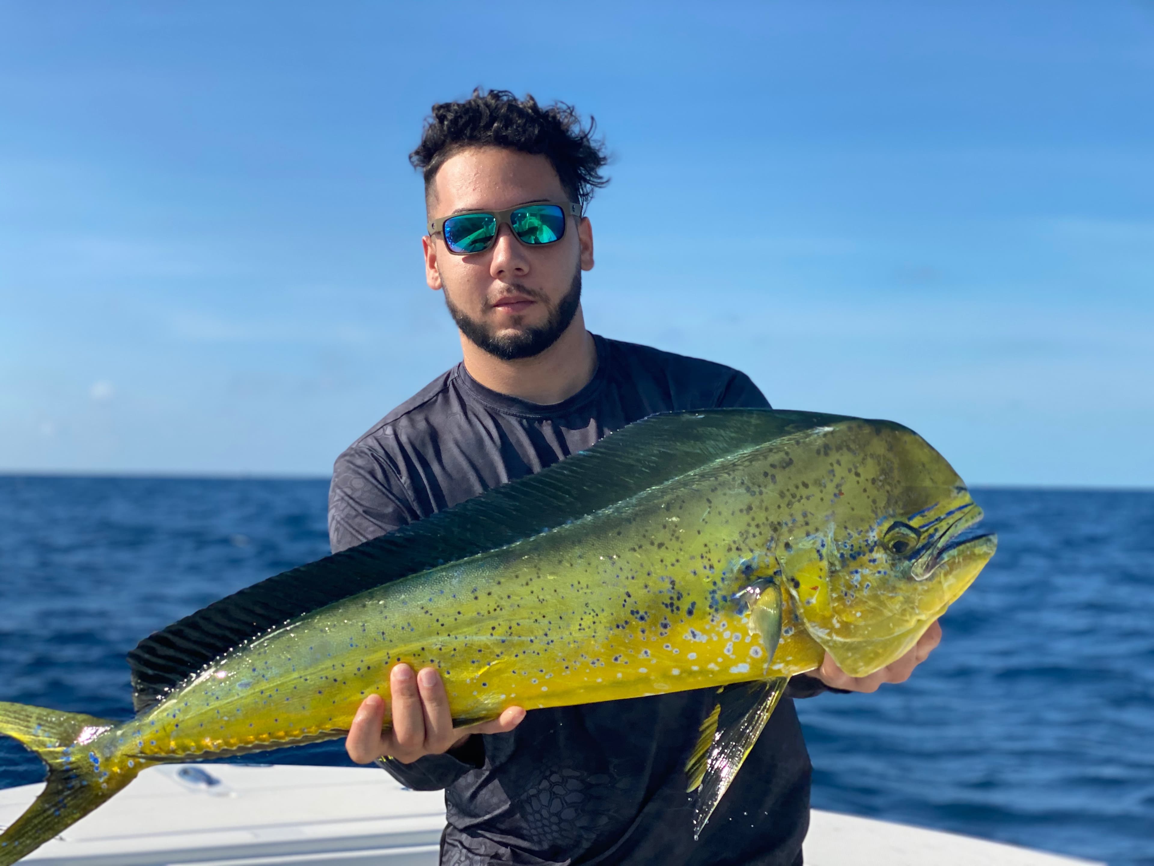 Angler holding a freshly caught mahi mahi offshore